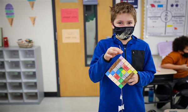 Boy holds up paper kite